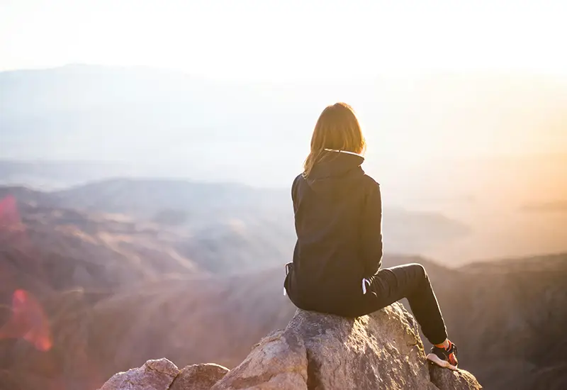 woman sitting on a mountain